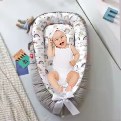 bebe-confortable-dans-reducteur-de-lit-arc-en-ciel