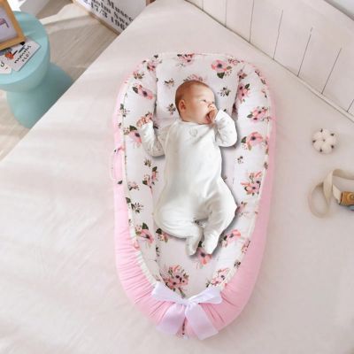 bebe-confortable-dans-reducteur-de-lit-rose